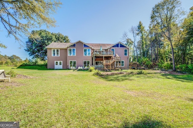 back of house featuring stairway, a deck, and a yard