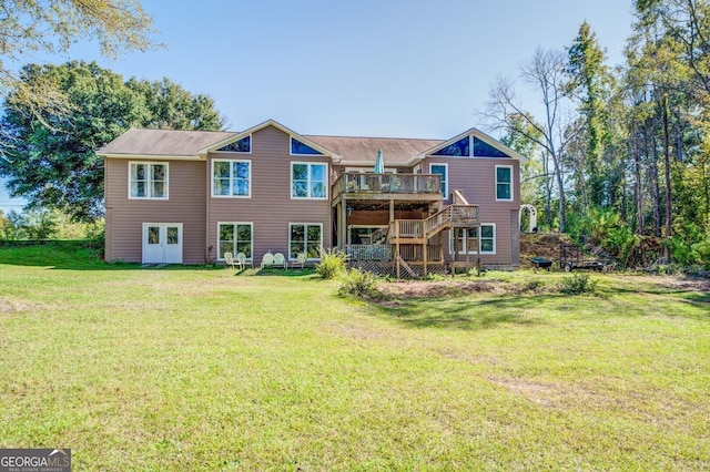 rear view of house with a yard, stairway, and a wooden deck