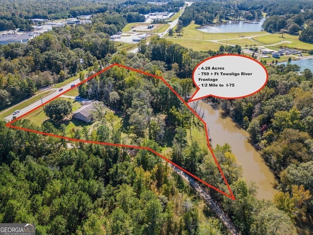 aerial view featuring a water view and a wooded view