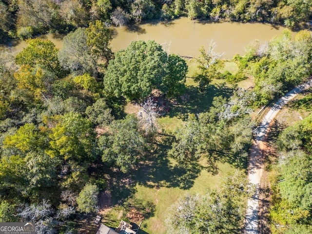 birds eye view of property featuring a water view and a wooded view