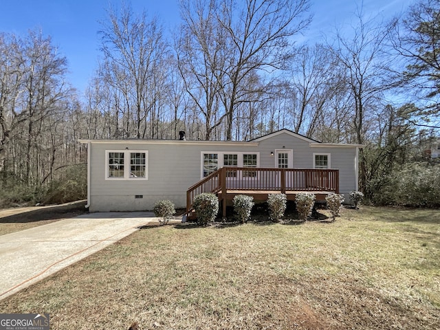 manufactured / mobile home with a deck, concrete driveway, crawl space, and a front yard