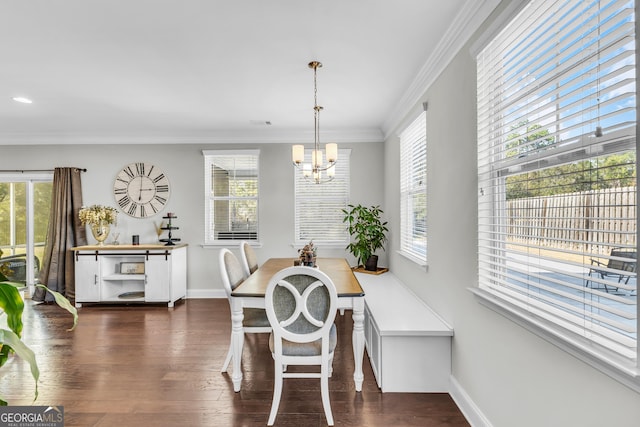 dining area featuring ornamental molding, a healthy amount of sunlight, dark wood-type flooring, and a notable chandelier