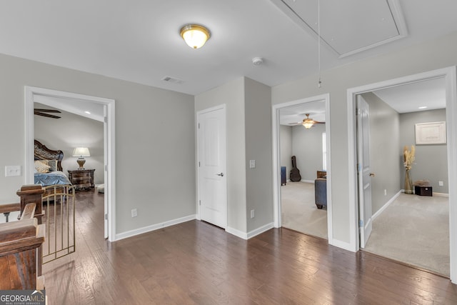 living area with attic access, wood-type flooring, and baseboards