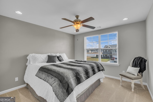 bedroom with light colored carpet, ceiling fan, and baseboards