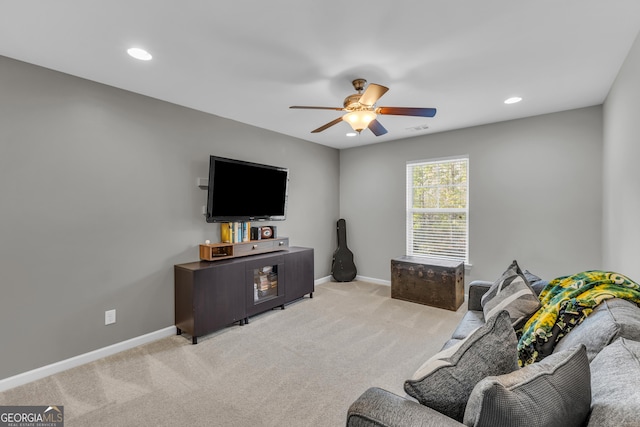 living room featuring light carpet, baseboards, and a ceiling fan