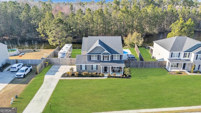 birds eye view of property with a water view and a view of trees