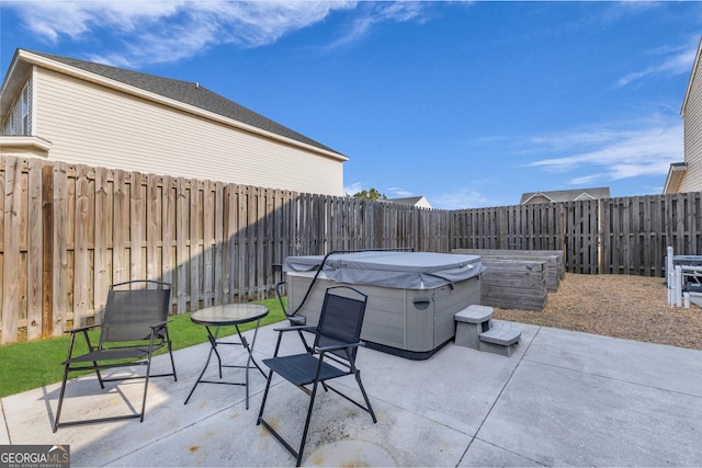 view of patio / terrace with a fenced backyard and a hot tub