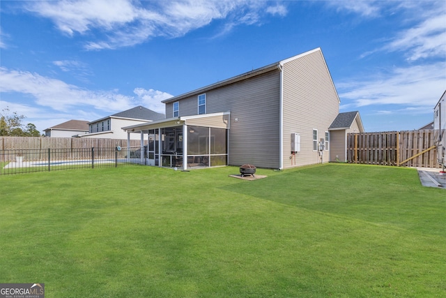 rear view of house with a yard, a fenced backyard, and a sunroom