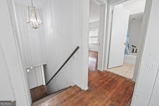 hallway with wood-type flooring and an upstairs landing