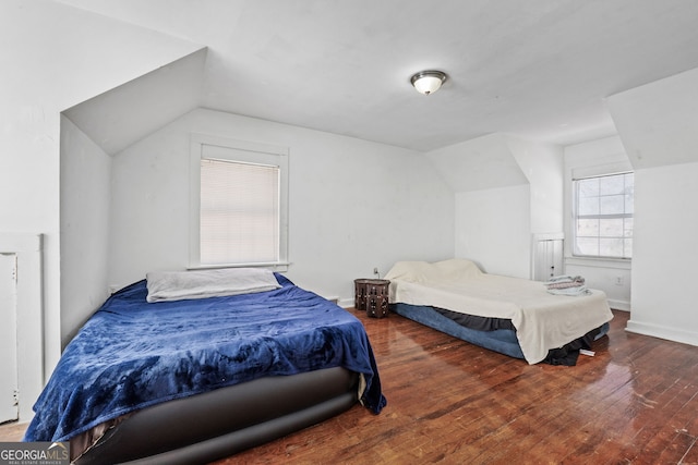 bedroom featuring vaulted ceiling, hardwood / wood-style flooring, and baseboards