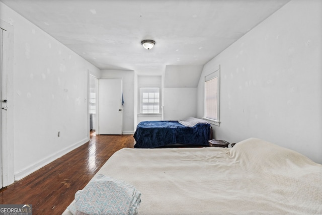 bedroom with wood-type flooring and baseboards