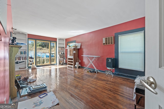 workout area featuring visible vents, baseboards, and wood finished floors