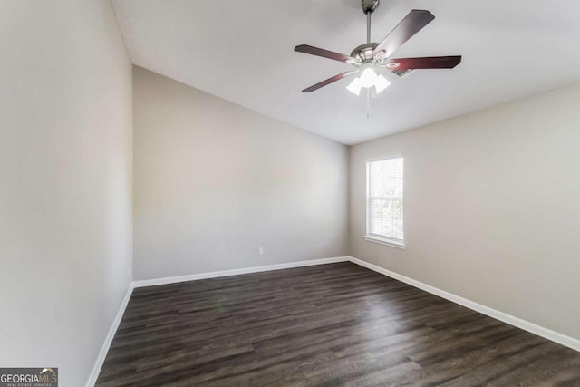 empty room with a ceiling fan, baseboards, and dark wood-type flooring