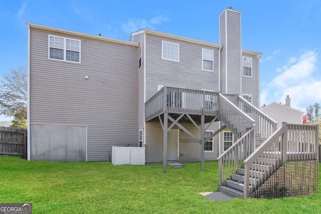 back of property with fence, stairs, a yard, a wooden deck, and a chimney