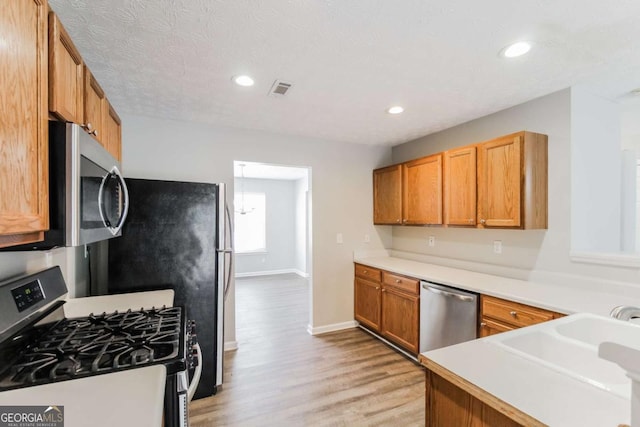 kitchen featuring recessed lighting, visible vents, appliances with stainless steel finishes, light wood-style floors, and a sink