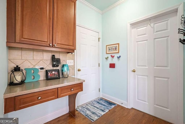 interior space featuring dark wood-style floors, baseboards, and ornamental molding