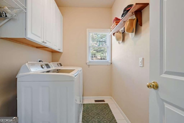 washroom featuring visible vents, baseboards, washer and dryer, cabinet space, and tile patterned floors