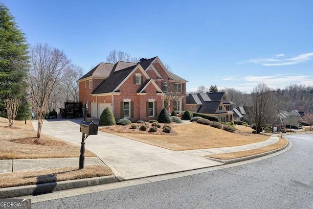 traditional-style house with a garage, concrete driveway, and brick siding