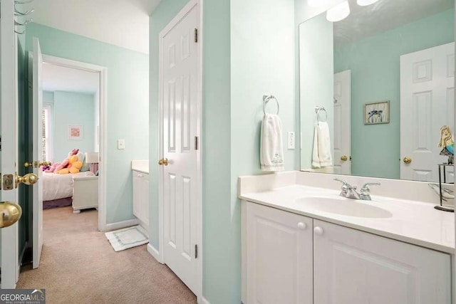 bathroom with baseboards, vanity, and ensuite bath