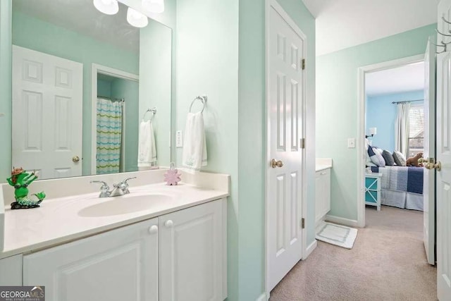 full bathroom with vanity, baseboards, and ensuite bathroom