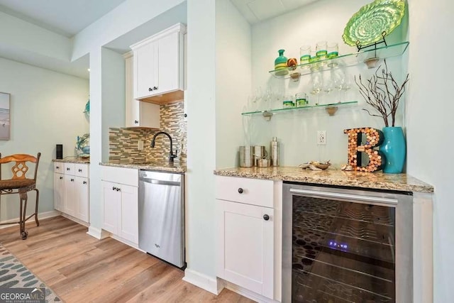 bar featuring a dry bar, light wood finished floors, tasteful backsplash, wine cooler, and stainless steel dishwasher