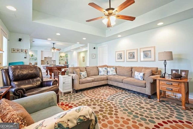 carpeted living room featuring ceiling fan, a tray ceiling, and recessed lighting