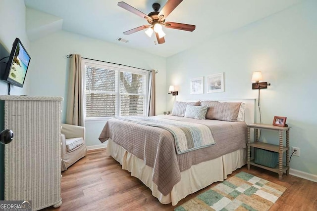 bedroom featuring baseboards, a ceiling fan, visible vents, and light wood-style floors