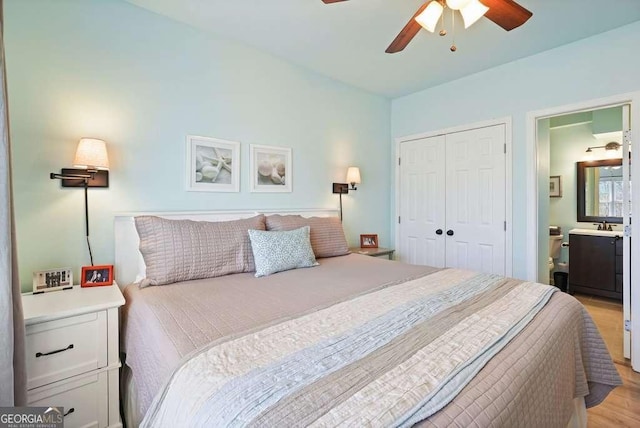 bedroom featuring a closet, ceiling fan, light wood-style flooring, and ensuite bath