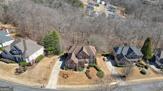 drone / aerial view featuring a forest view and a residential view