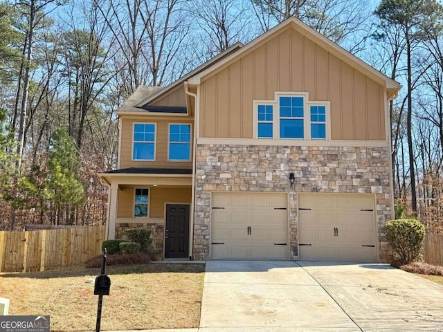 view of front of house with an attached garage, board and batten siding, fence, stone siding, and driveway