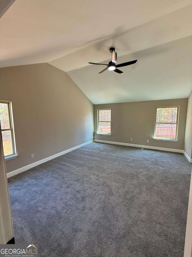 unfurnished room featuring lofted ceiling, dark colored carpet, ceiling fan, and baseboards