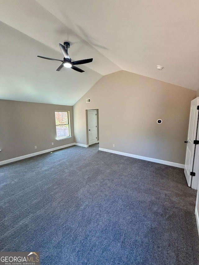 empty room with ceiling fan, visible vents, baseboards, vaulted ceiling, and dark colored carpet