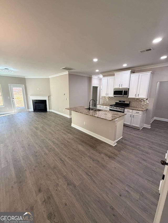 kitchen with backsplash, appliances with stainless steel finishes, dark wood-type flooring, and crown molding