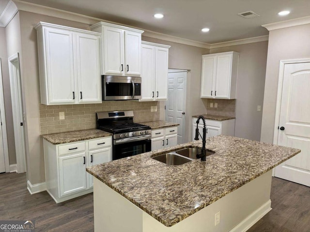 kitchen with stone counters, dark wood-style flooring, a sink, visible vents, and appliances with stainless steel finishes