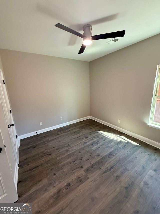 unfurnished room featuring ceiling fan, dark wood-style flooring, visible vents, and baseboards