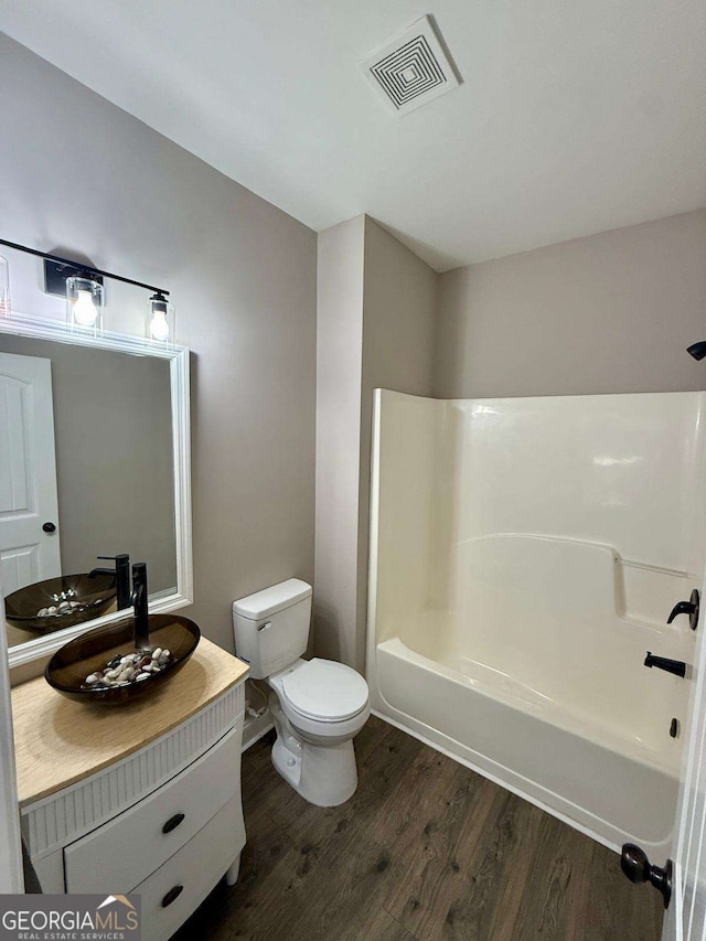 full bathroom featuring visible vents, toilet, shower / tub combination, wood finished floors, and vanity