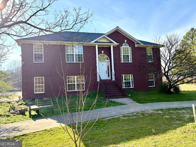 split foyer home featuring brick siding and a front yard