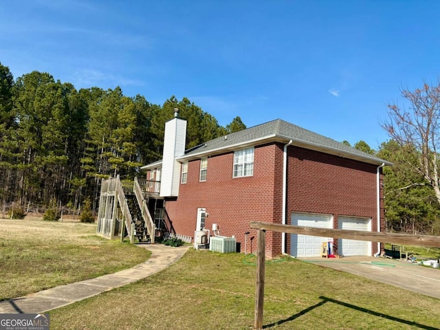 view of home's exterior featuring driveway, a lawn, an attached garage, stairs, and brick siding