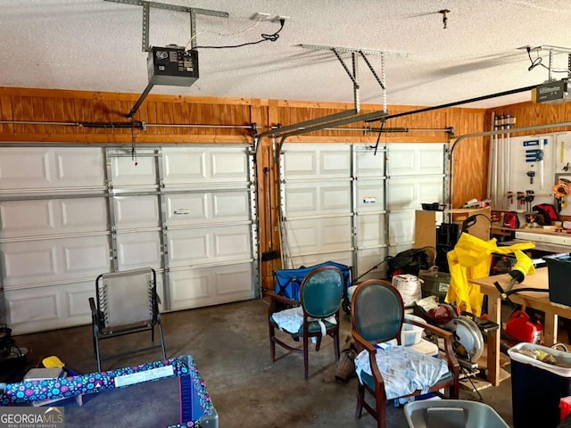 garage featuring a garage door opener and wooden walls