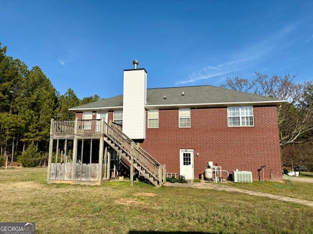 back of house featuring a lawn, a chimney, stairway, cooling unit, and brick siding