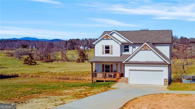 view of front of house with a garage, concrete driveway, a front lawn, and a mountain view