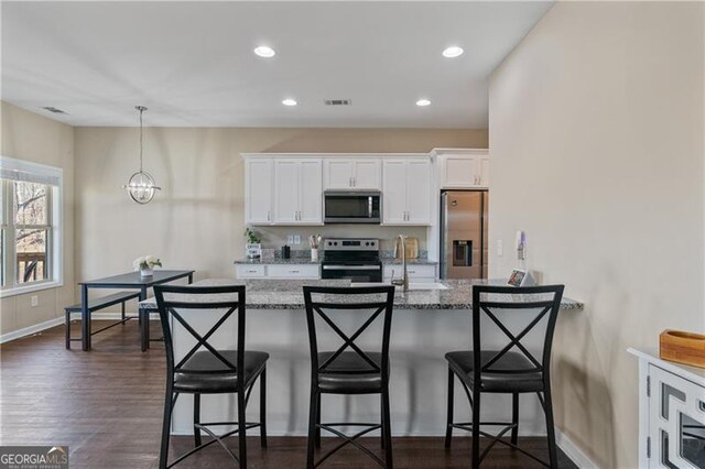 kitchen with white cabinets, visible vents, stainless steel appliances, and dark wood-style flooring