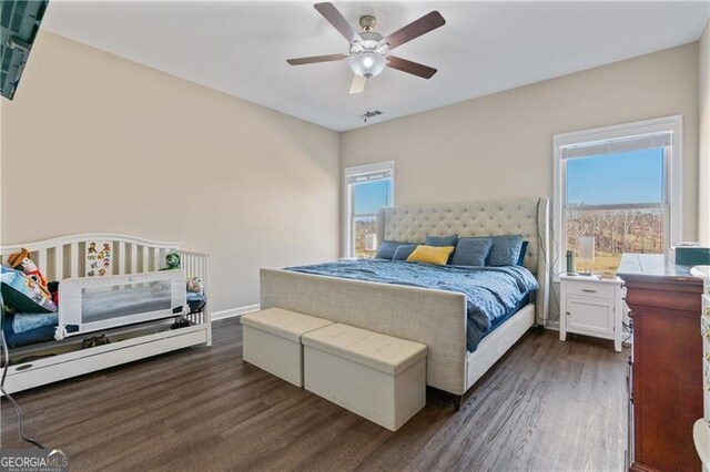 bedroom featuring ceiling fan, dark wood-type flooring, and baseboards