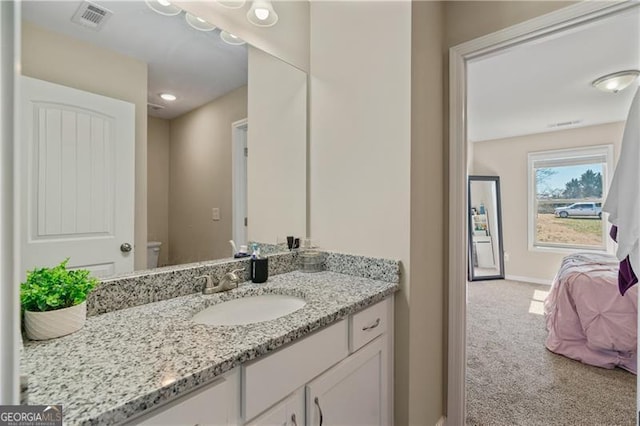 bathroom featuring toilet, baseboards, visible vents, and vanity