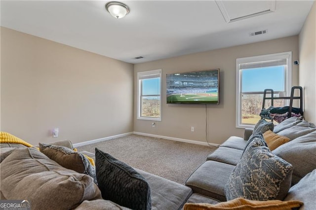 living area with plenty of natural light, carpet flooring, visible vents, and baseboards