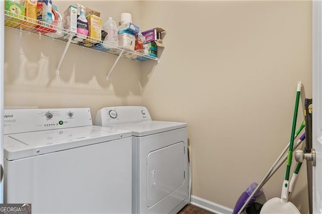 clothes washing area with laundry area, baseboards, and separate washer and dryer