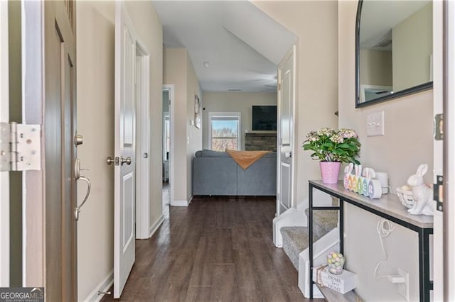 corridor featuring baseboards and dark wood finished floors