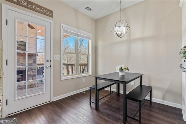 dining space with baseboards, visible vents, dark wood finished floors, and a chandelier