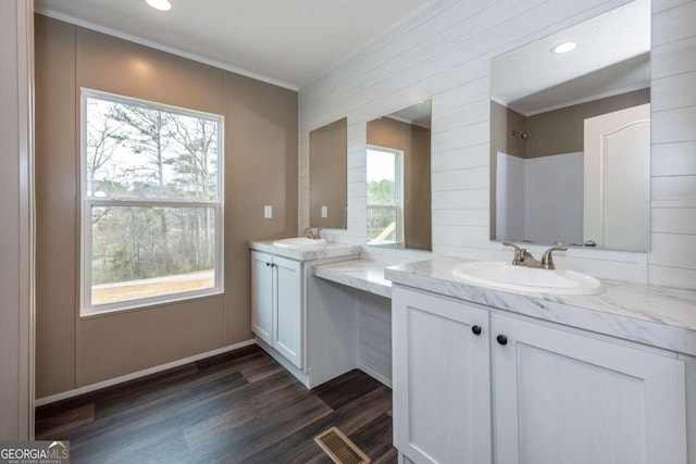 2859 Fortner Rd, Ball Ground, GA 30107 - full bath featuring ornamental molding, healthy amount of natural light, two vanities, wood finished floors, and a shower