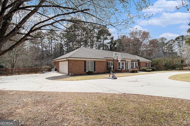 view of front facade with a garage, brick siding, fence, concrete driveway, and a front lawn